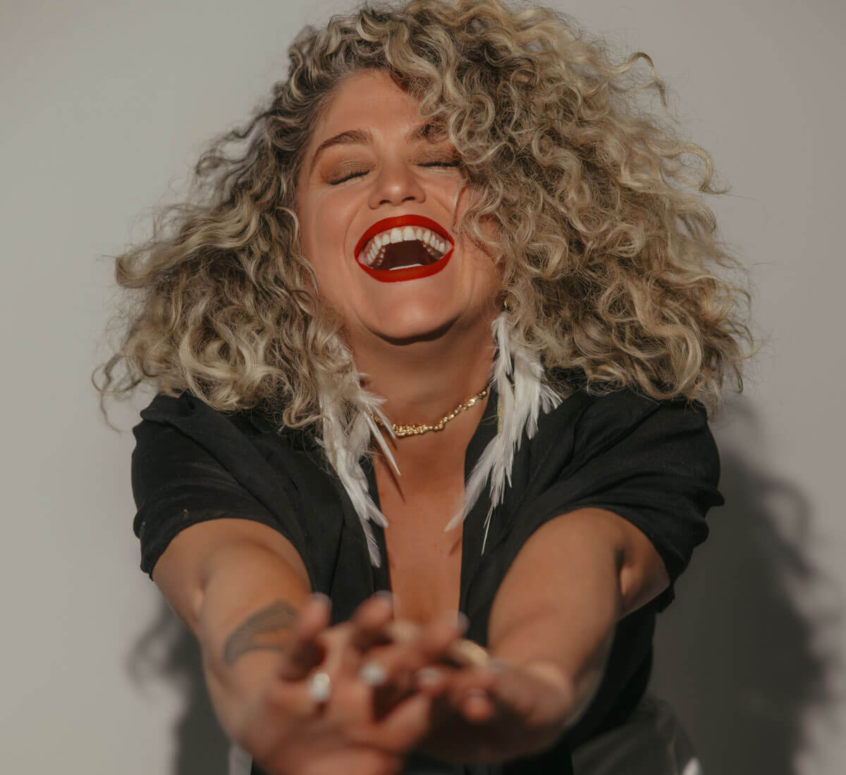 Woman with curly hair laughing.